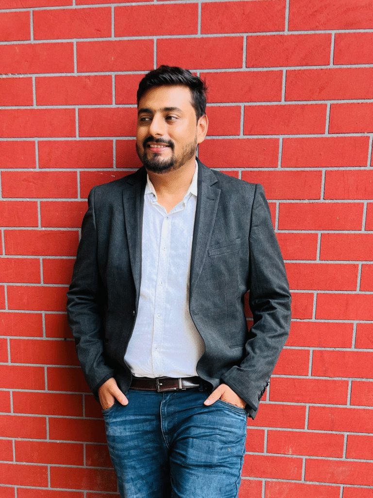 a man standing in front of a brick wall